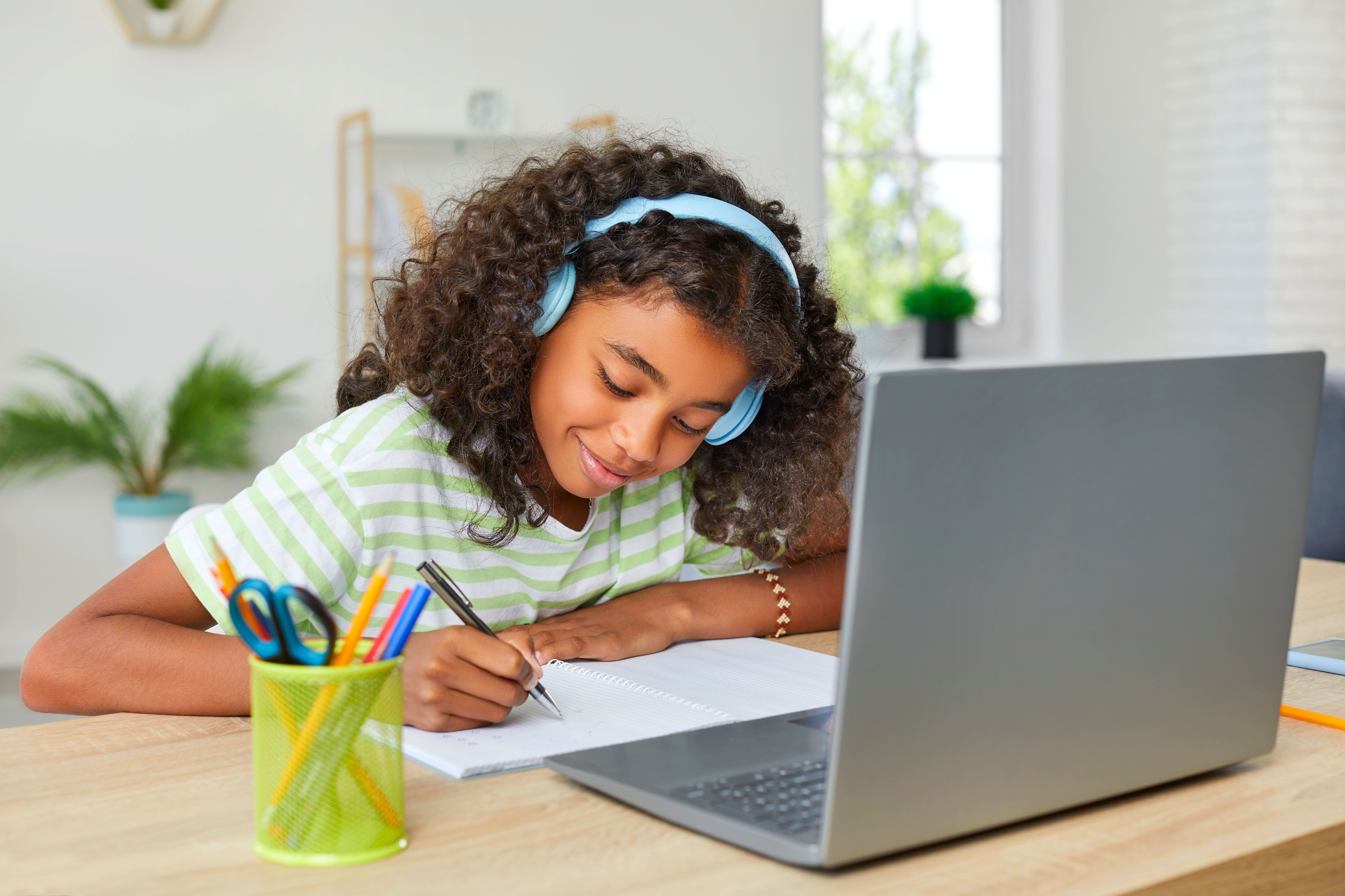 Young girl learning at home with a laptop computer