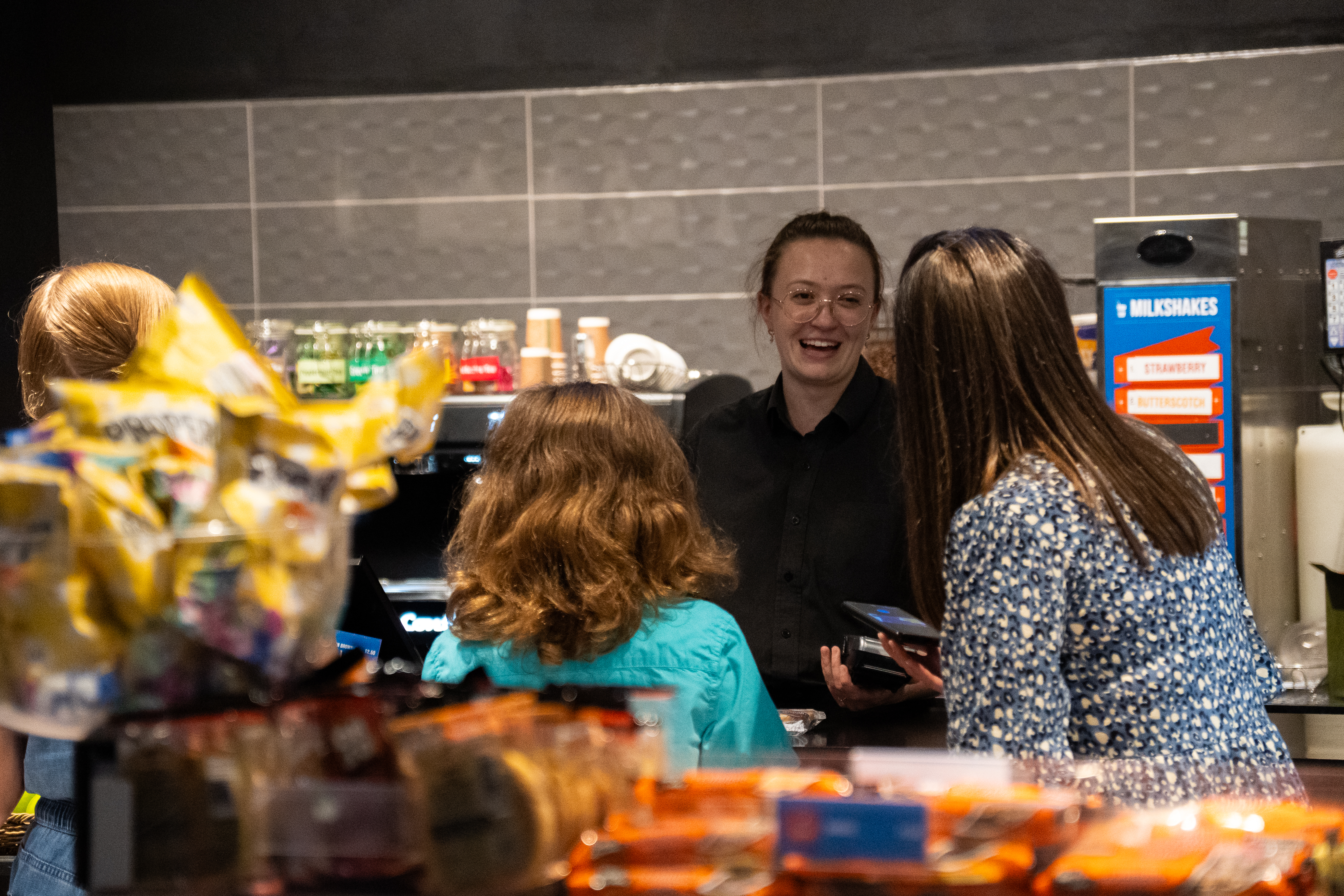 Space Crew team member happily serving a family in Boosters cafe