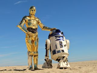 C-3PO and R2-D2 stood in the sandy desert on Tatooine.