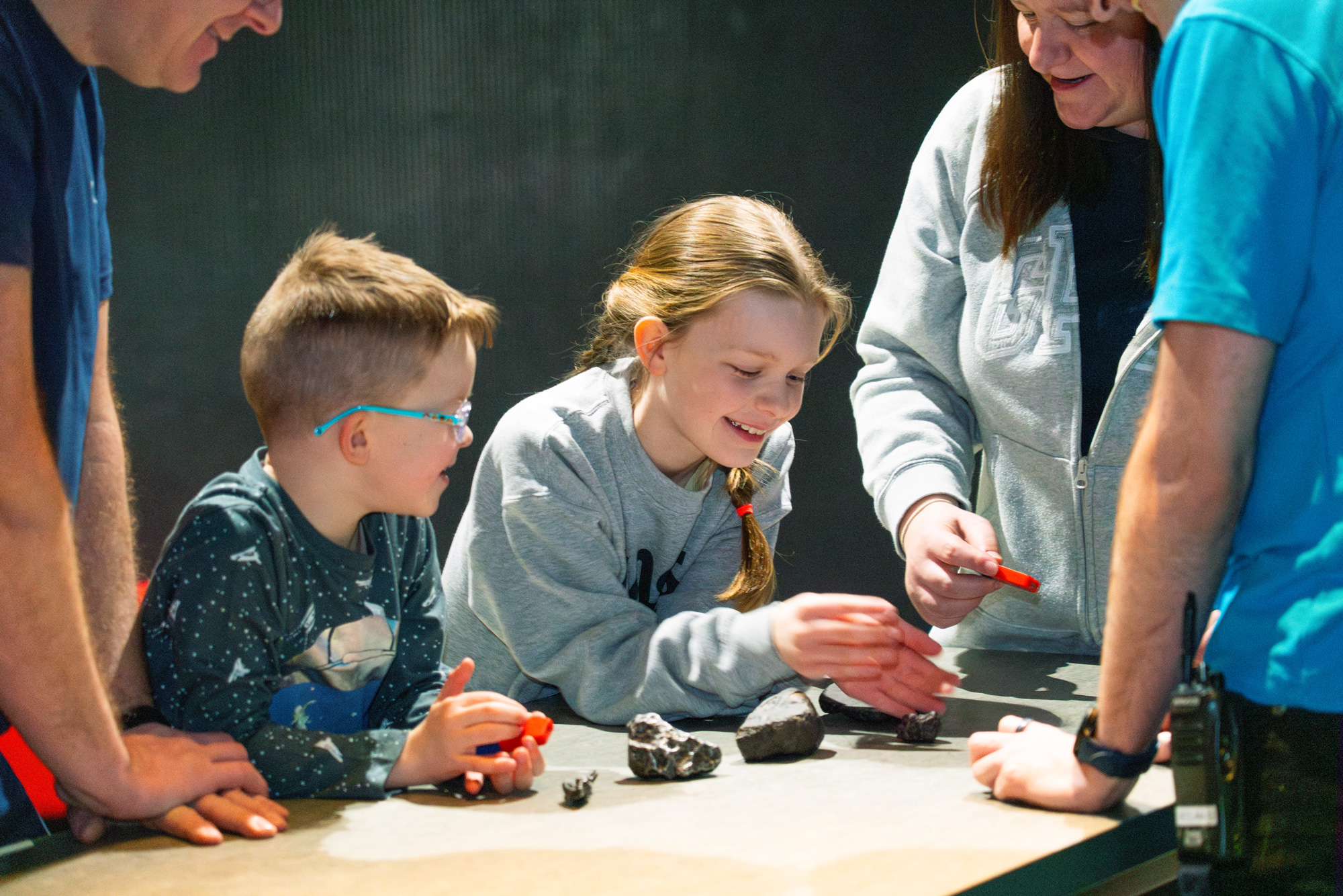 Two children and their parents testing meteorites with magnets