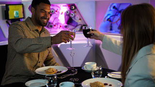 Couple raising a glass at Destination Dining in Tetrastar room