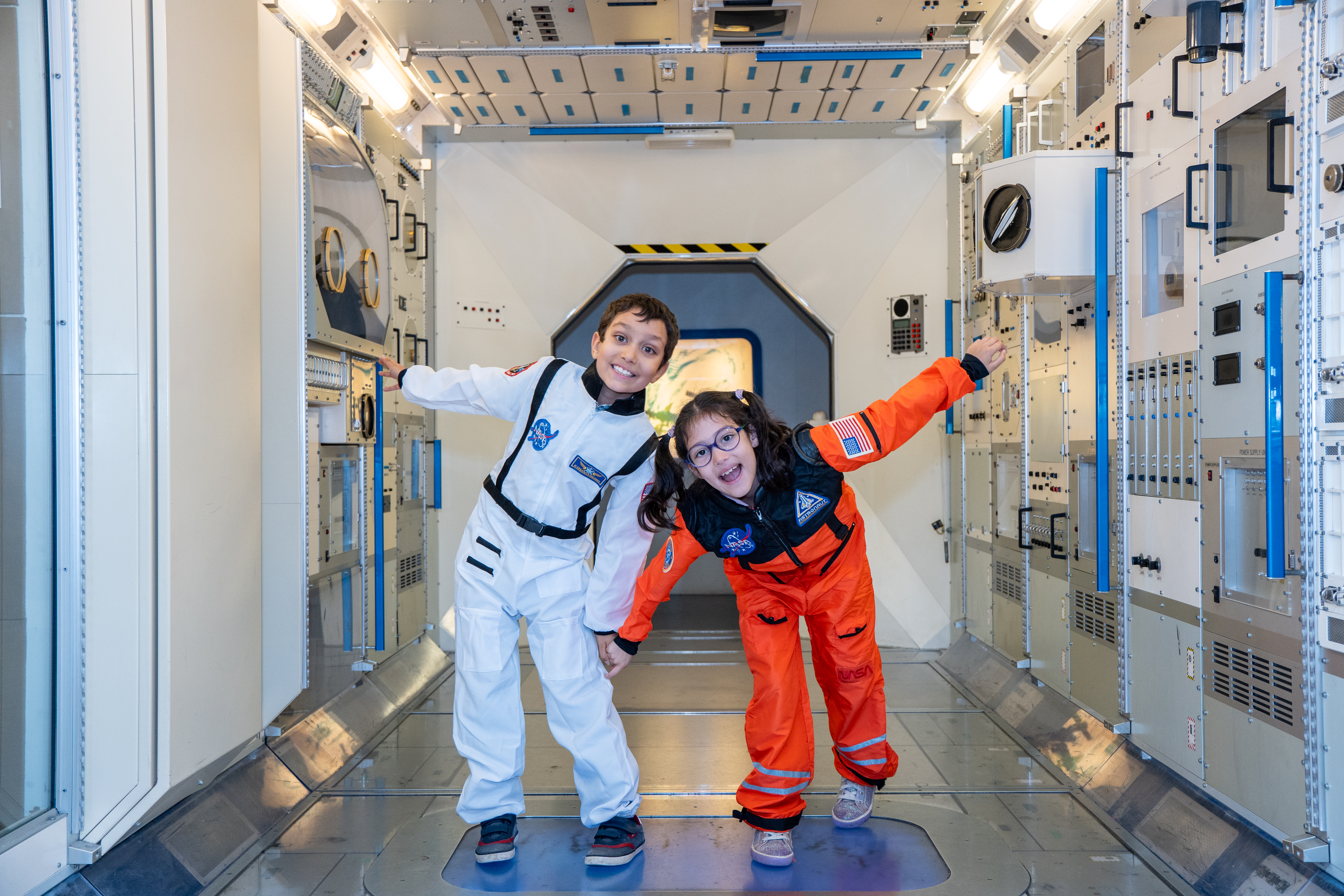 Two children in spacesuits in the Columbus Module in the Into Space gallery