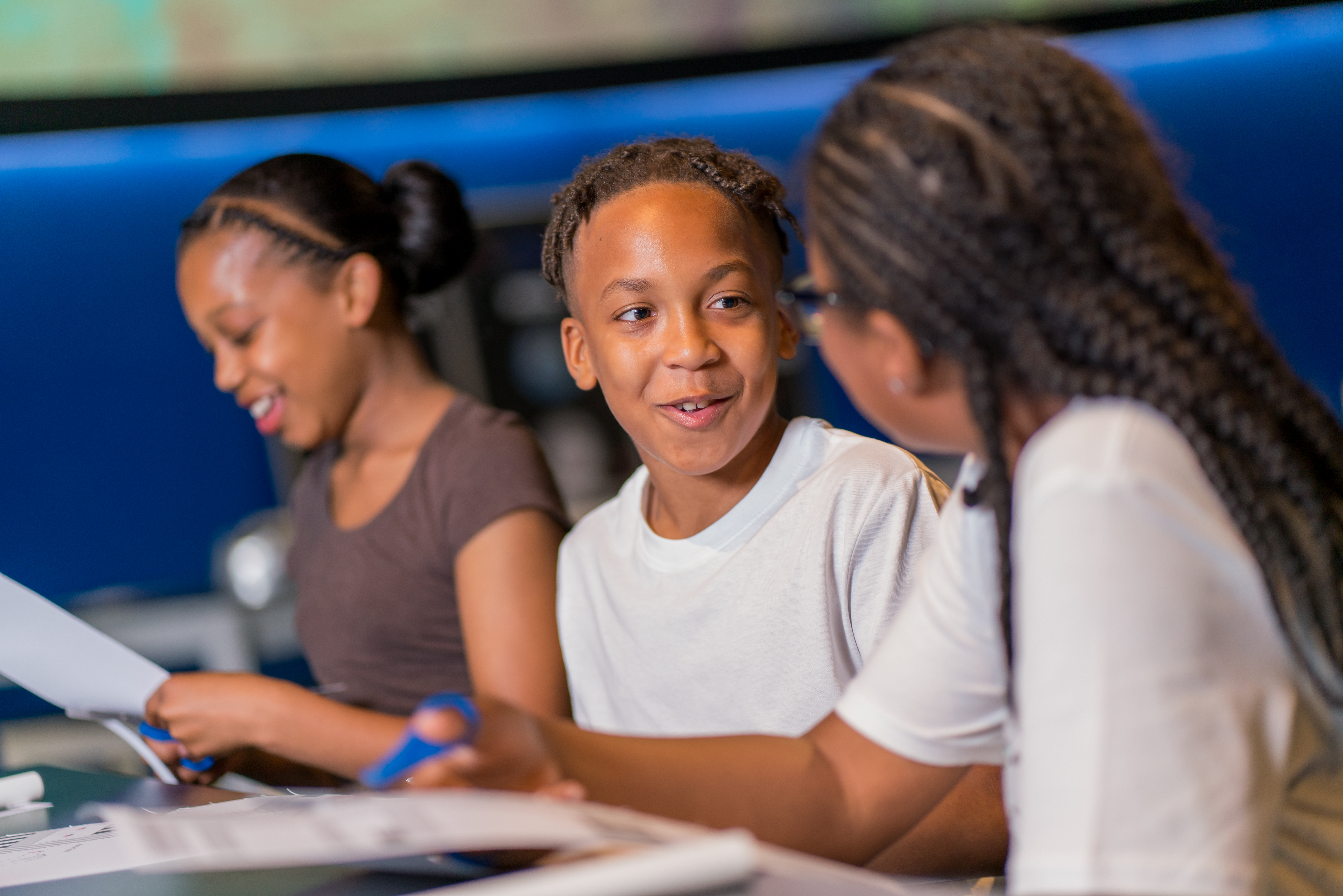 Three happy children making paper rockets in Home Planet gallery