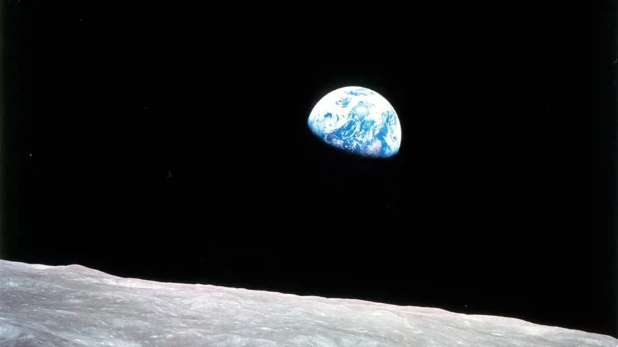 NASA Photo Earthrise, famously taken by Apollo 8 Pilot William Anders on 24th December 1968. The Earth can be seen, half covered by shadow, with the Lunar surface at the bottom.