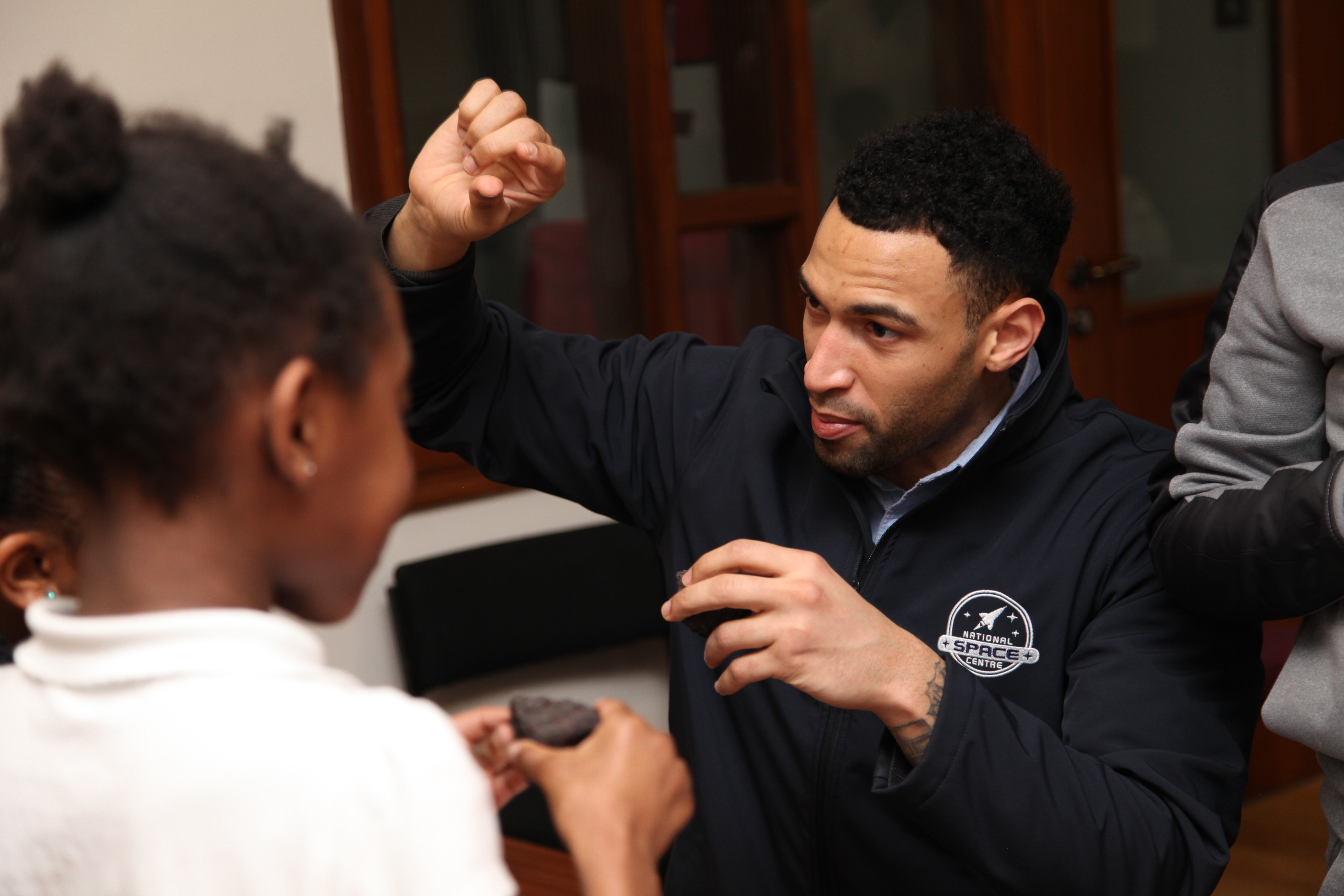IGNITE Programme manager explaining meteorites to a child 