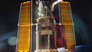 A shiny Hubble Space Telescope docked onto the Space Shuttle Endeavour after SM1 showing it's new solar array.