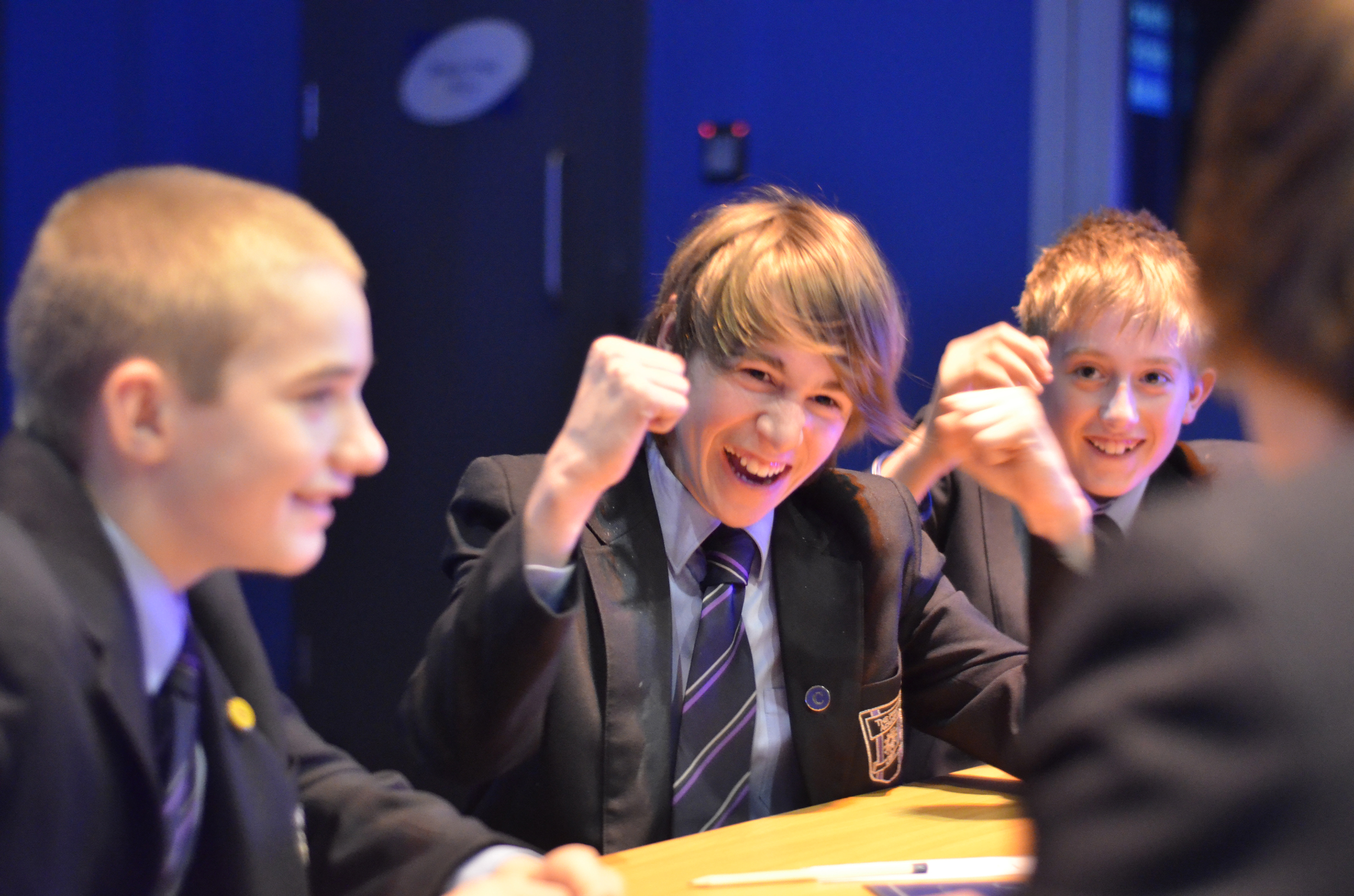 School children sat around a table, cheering.