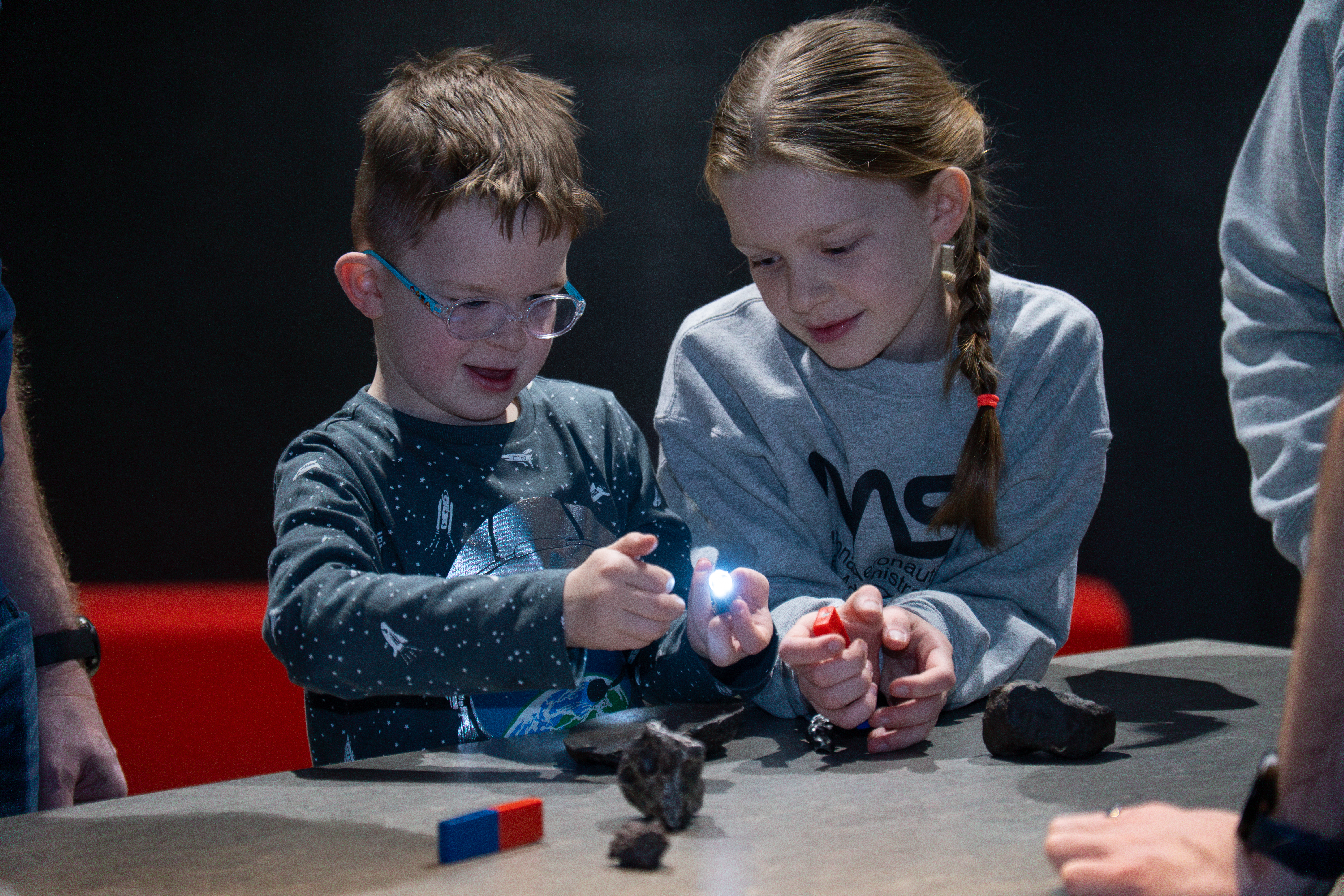 Two children with meteorites and magnets in the galleries