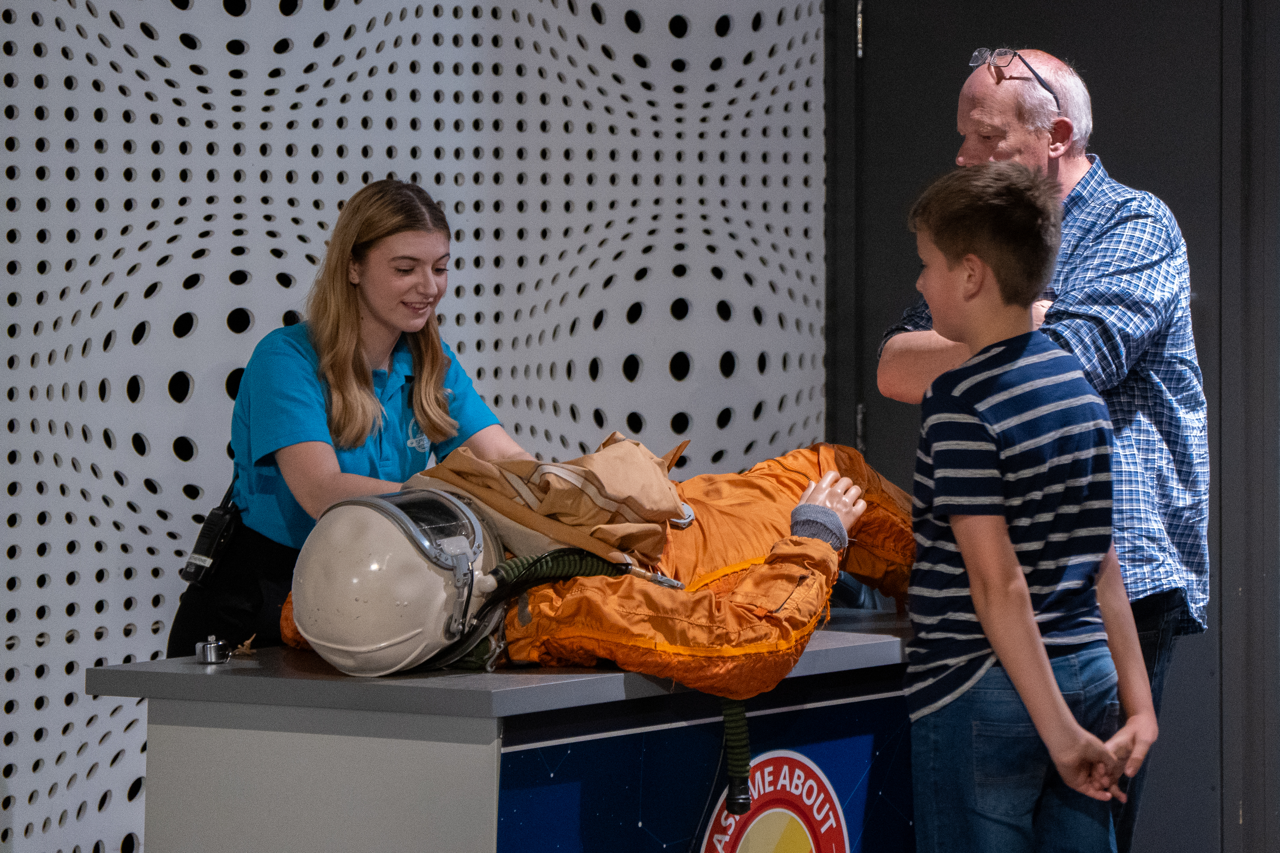 Science busk with a spacesuit is enjoyed by a young boy and Father