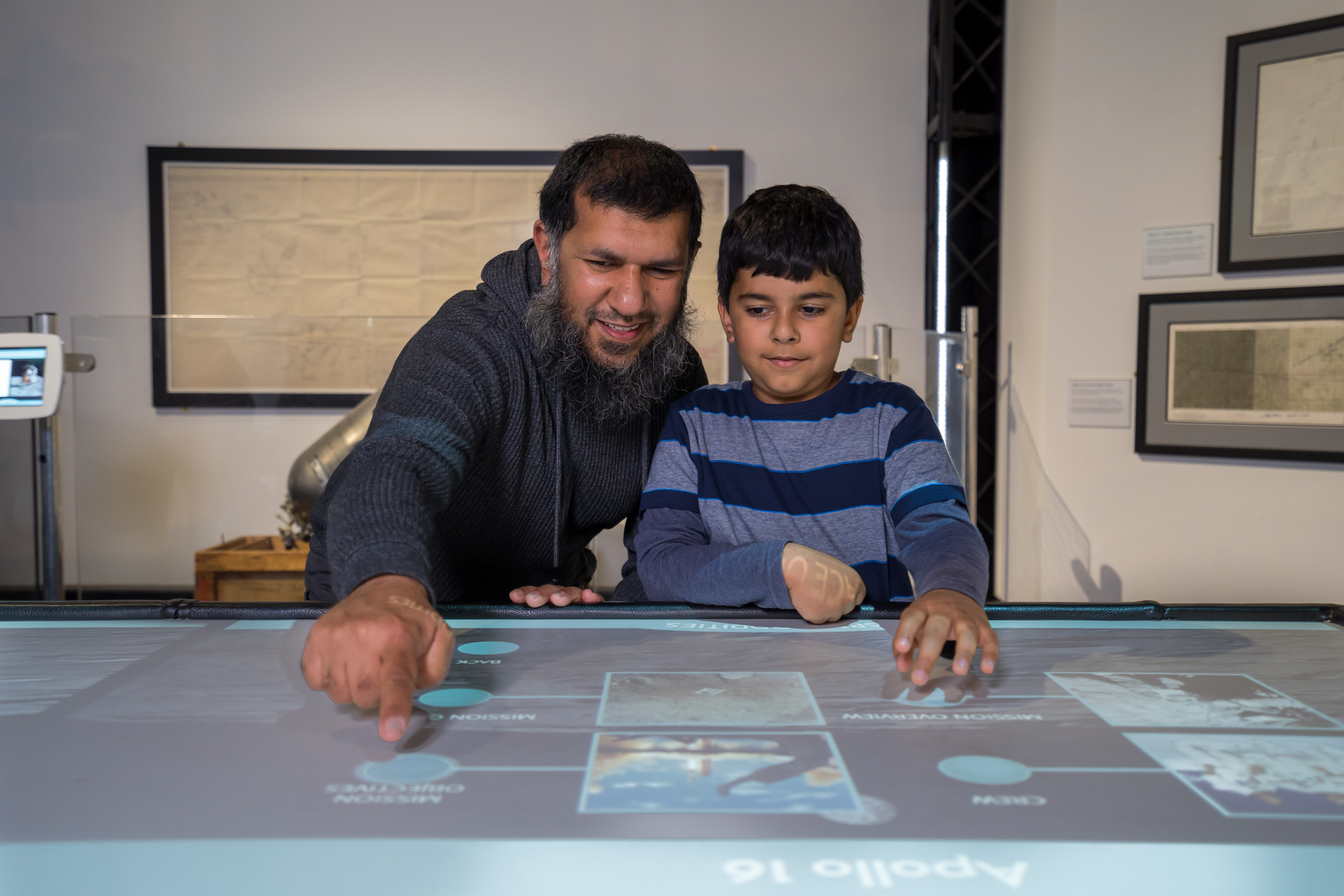 Father and son interacting with touch table in Space Oddities gallery
