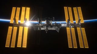 A photo of the International Space Station with a backdrop of space and the thin blue line of Earth's atmosphere.