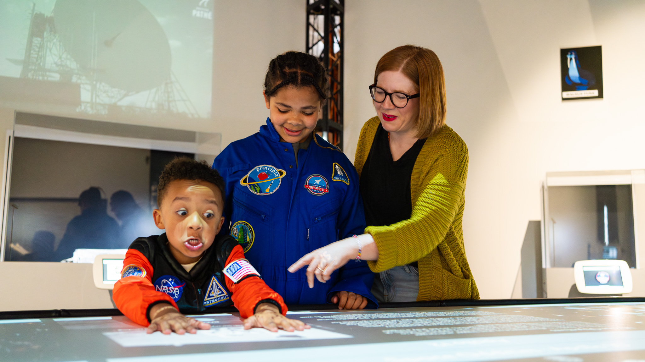 Family interacting with the touch table display in Space Oddities