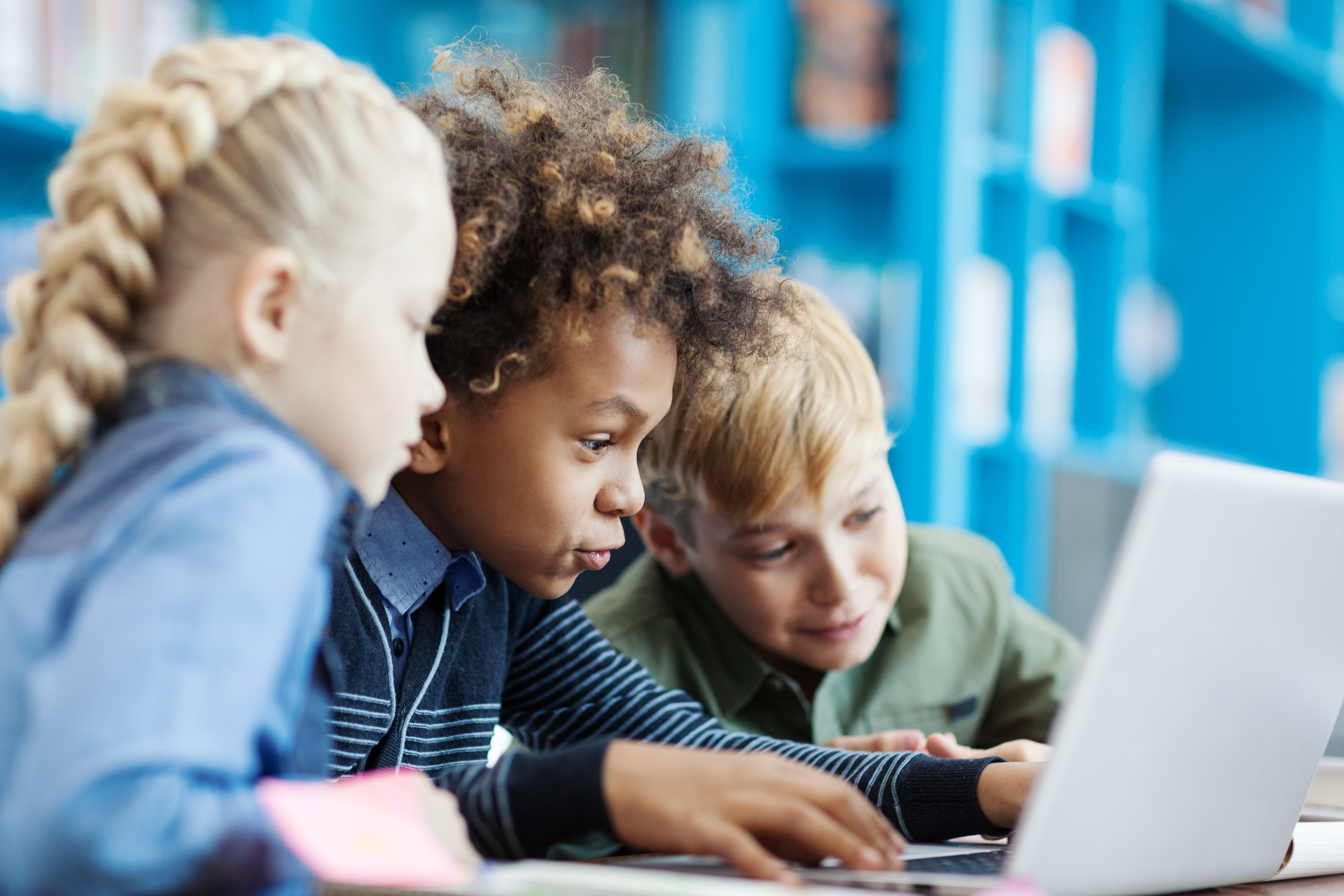 Three children learning online with a laptop computer