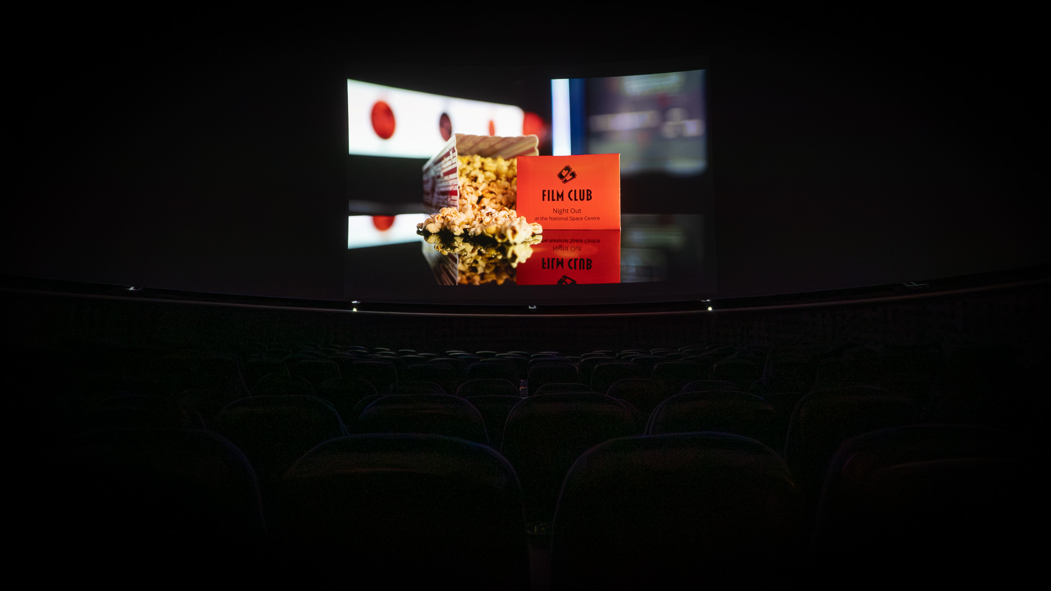 Film Club Voucher and popcorn displayed on the planetarium screen 