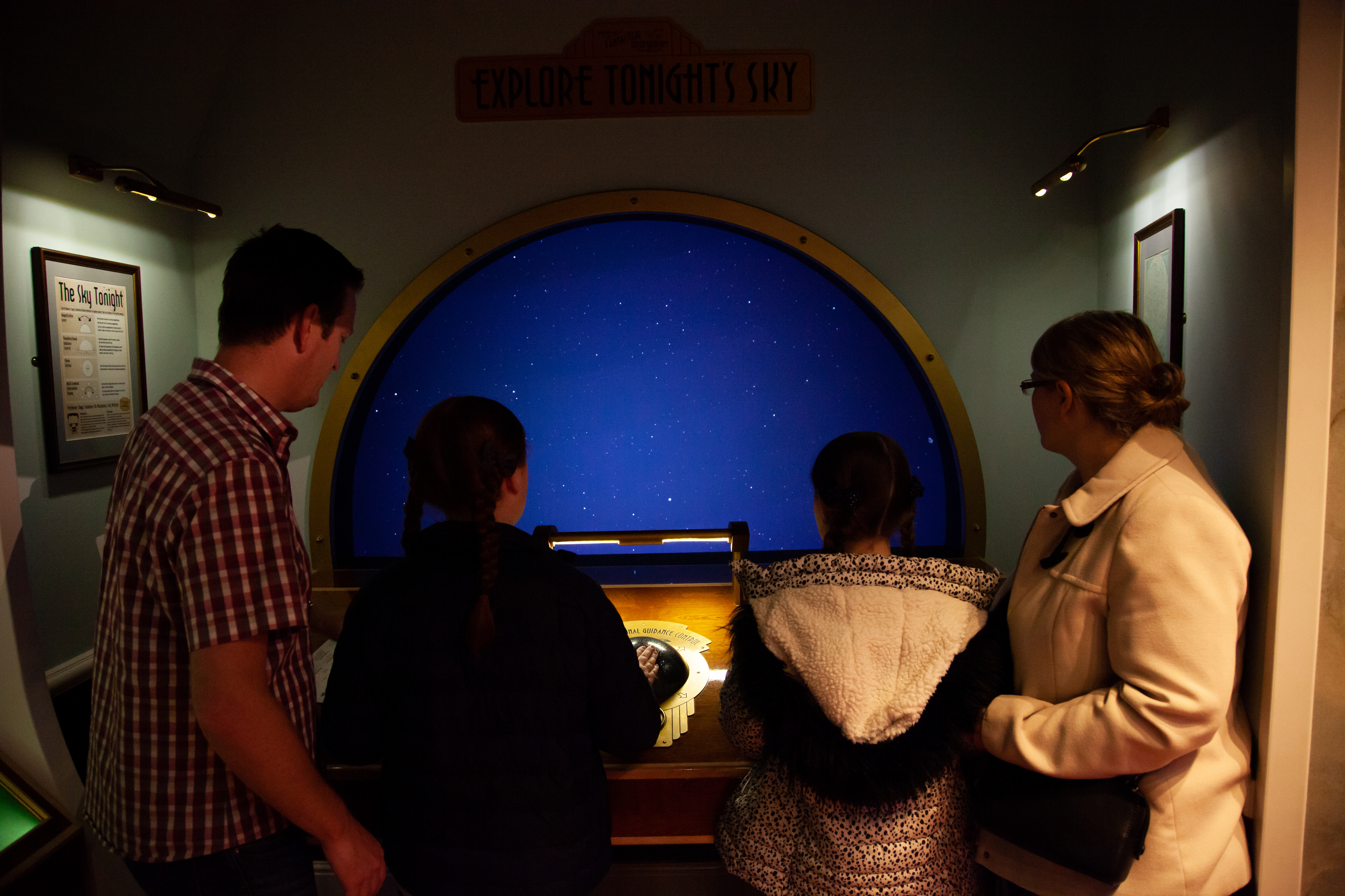 A family exploring the night sky using an Observatory in the National Space Centre.