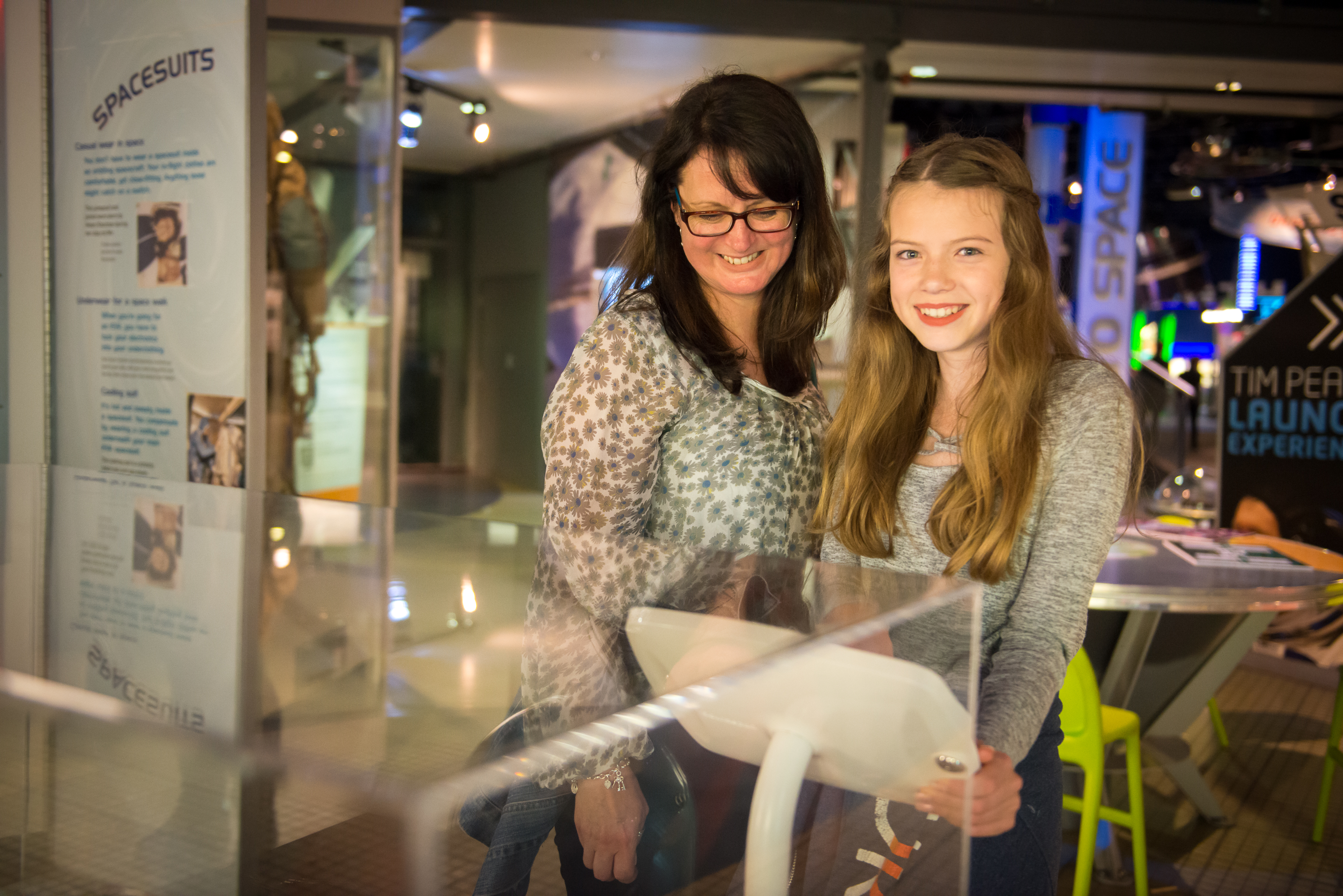 Mother and teen looking at artefacts in Into Space gallery
